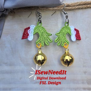 May include: A pair of Christmas-themed earrings. Each earring features a green hand design with a red and white cuff, and a dangling gold-colored bell. The earrings are suspended from silver-colored hooks. The text "ISewNeedIt / Digital Download FSL Design" is also visible.
