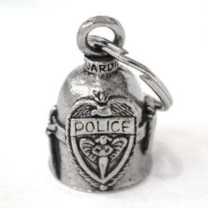 May include: A silver-colored motorcycle bell shaped like a police helmet. The bell features a shield with the word "POLICE" and an emblem. A key ring is attached to the top. The bell is designed to be a guardian bell for motorcycles.