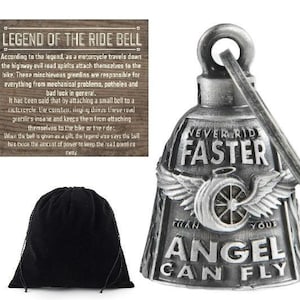 May include: A silver motorcycle ride bell with the text "NEVER RIDE FASTER THAN YOUR ANGEL CAN FLY" and a small black bag. The bell has a turbine design with wings and a loop for hanging. A wooden sign with text is also visible.
