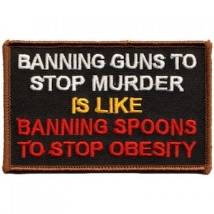 May include: Black embroidered patch with white, yellow, and red text. The text reads "Banning guns to stop murder is like banning spoons to stop obesity."