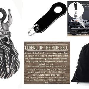 May include: A silver motorcycle keychain with a Viking skull design. The keychain includes a small bell and a legend about the ride bell. The image also shows a black motorcycle, a black drawstring bag, and a black key ring.