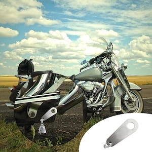 May include: A silver motorcycle with chrome accents is parked on a paved road under a cloudy sky. A close-up shows a silver motorcycle bell with a skull design. The bell is attached to a silver bracket with a hole for mounting.