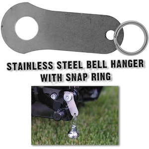 May include: A stainless steel bell hanger with a snap ring. The hanger is a flat, gray metal piece with a large circular hole and a smaller hole. A silver snap ring is attached. The text "STAINLESS STEEL BELL HANGER WITH SNAP RING" is displayed.