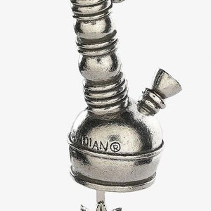 May include: Silver charm in the shape of a bong with a marijuana leaf pendant. The charm is engraved with the word "Indian" and a registered trademark symbol.