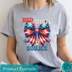 May include: A light gray t-shirt featuring a patriotic bow design in red, white, and blue. The bow is adorned with stars and stripes, with the words "RED WHITE & BOUJEE" in a stylized font.