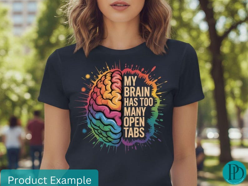 May include: Navy blue t-shirt featuring a colorful brain graphic with the text "MY BRAIN HAS TOO MANY OPEN TABS". The brain illustration is in shades of orange, yellow, green, blue, and purple. The shirt is a casual wear item.