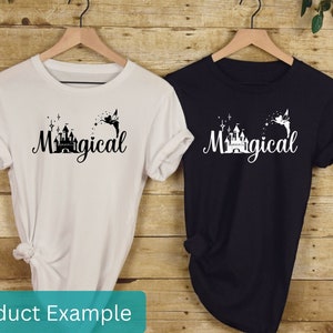 May include: Two t-shirts with a black and white graphic of a castle and a fairy with the word "Magical" printed on them. One t-shirt is white and the other is black.