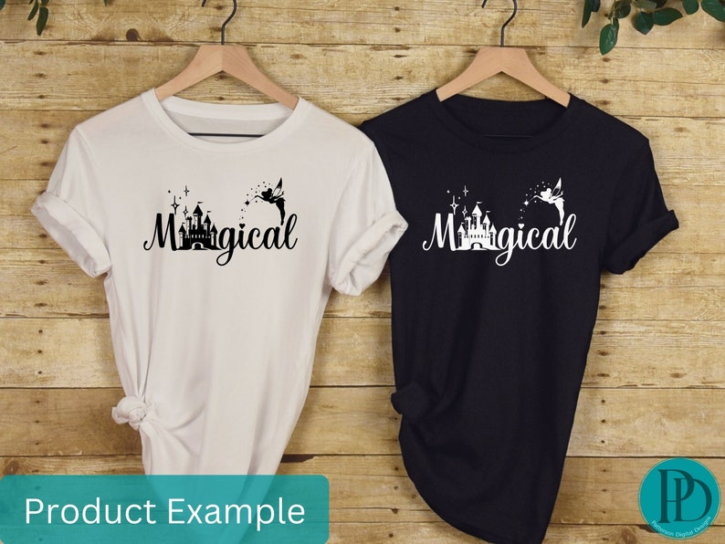 May include: Two t-shirts with a black and white graphic of a castle and a fairy with the word "Magical" printed on them. One t-shirt is white and the other is black.
