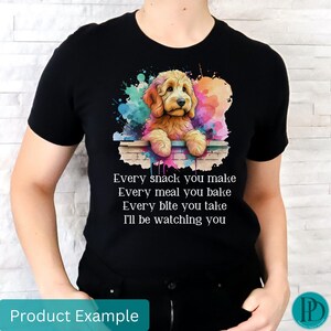 May include: A black t-shirt with a watercolor illustration of a golden doodle dog peeking over a brick wall. The text "Every snack you make Every meal you bake Every bite you take I'll be watching you" is printed on the shirt.