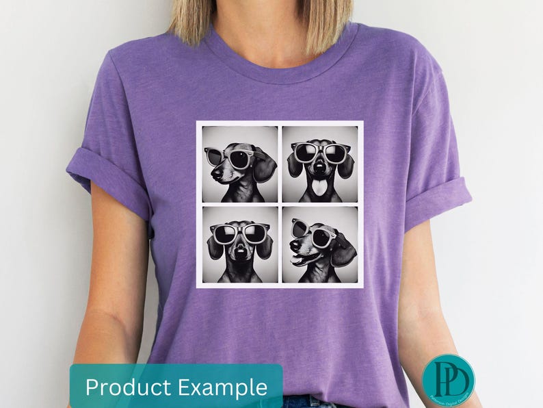 May include: A purple t-shirt with a graphic of four dachshunds wearing sunglasses. Each dachshund is in a separate square. The dachshunds are black and white.