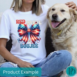 May include: White t-shirt with a patriotic bow graphic in red, white, and blue, with the words "Red White & Boujee". The shirt is worn with blue jeans. A golden retriever dog is in the image.
