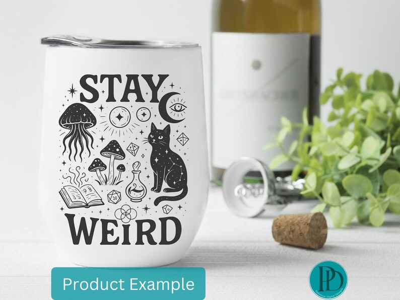 May include: White stemless wine tumbler with a black graphic design featuring a cat, mushrooms, and the words "STAY WEIRD". A bottle of wine, a corkscrew, and a cork are in the background.