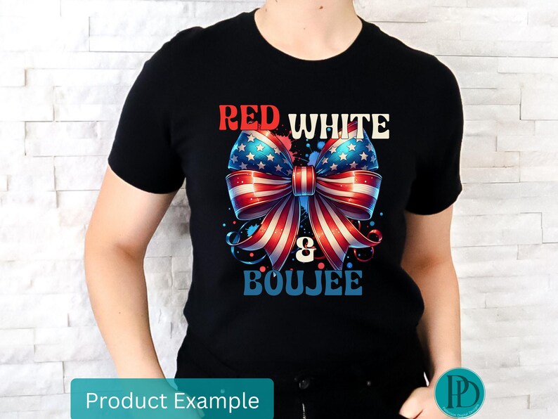 May include: Black t-shirt featuring a patriotic bow design in red, white, and blue, with the words "RED WHITE & BOUJEE" in a stylized font. The bow has a star-spangled pattern and striped ribbons.