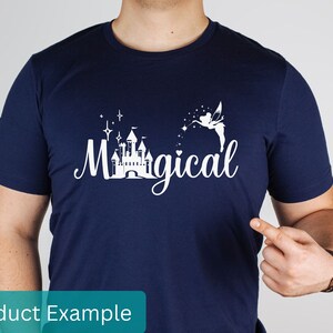 May include: A navy blue t-shirt with a white graphic design featuring a castle, stars, a fairy, and the text "Magical".