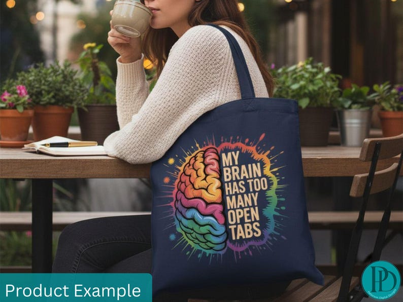 May include: Navy blue tote bag featuring a colorful brain graphic with the text "MY BRAIN HAS TOO MANY OPEN TABS." The brain illustration is in rainbow colors. The bag has a dark blue handle.