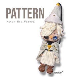Op de afbeelding: Een gehaakte pop met een witte puntmuts, wit haar en een witte mantel met gouden accenten. De pop draagt een zwarte ooglap, een blauwe monocle en bruine laarzen. De tekst in de afbeelding luidt: PATTERN Witch Hat Wizard aquarisbyf.