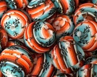 May include: A collection of round wooden beads with a turquoise, orange, and brown geometric pattern. The beads are perfect for crafting jewelry or other decorative projects.