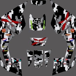 May include: A set of black and white camouflage vinyl decals for a Can-Am Renegade ATV. The decals feature the Can-Am logo, the Fox Racing logo, and the words "Renegade" and "Can-Am Team".