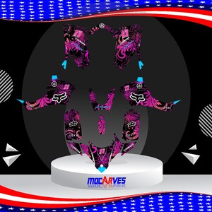 Può includere: Design grafico rosa e nero per una moto Yamaha con logo Fox Racing. Il design presenta motivi floreali e il logo Yamaha.
