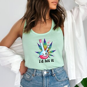 May include: A light green tank top with a graphic of a cartoon bong with a smiling face and a rainbow colored design. The bong is surrounded by a green marijuana leaf. The text "I'd hit it" is printed below the bong.