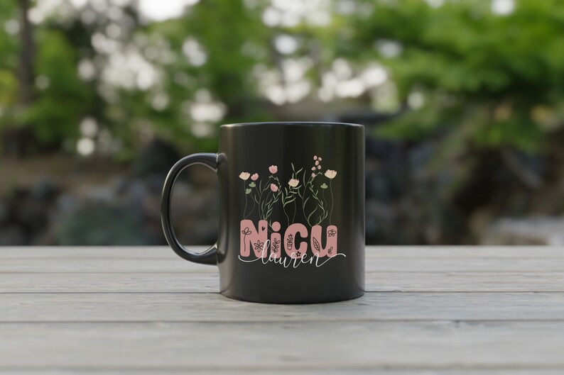 May include: Black ceramic mug with a pink floral design and the text "NICU Lauren" on it.