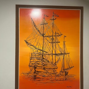 May include: A framed painting featuring a black ink line drawing of a multi-masted sailing ship on a vibrant orange and yellow gradient background. The artwork depicts a detailed vessel with intricate rigging and sails, signed EdLtta.