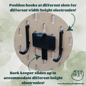 May include: Black pegboard hooks with a sliding back keeper that can be adjusted to accommodate different sized electronics. The text "Just Hanging Pegboards" is visible in the bottom right corner of the image.