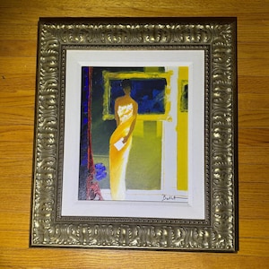 May include: An original framed painting featuring a woman in a yellow dress holding a white envelope. The artwork has a gold frame and is set against a backdrop of blue and yellow hues. The painting is signed in the bottom right corner.
