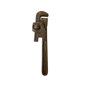 May include: A vintage, rusty pipe wrench, a hand tool used for gripping and turning pipes. The wrench is made of metal and has a long handle with a textured grip. The adjustable jaws are open, ready for use.