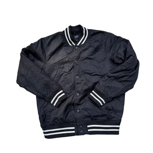Puede incluir: Chaqueta bomber negra con rayas blancas en el cuello, los pu&ntilde;os y el dobladillo. La chaqueta tiene una parte delantera abotonada y un estilo universitario cl&aacute;sico. La chaqueta est&aacute; hecha de un material ligero.