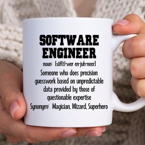 May include: White ceramic mug with a black design that reads "SOFTWARE ENGINEER" and defines the term as "Someone who does precision guesswork based on unpredictable data provided by those of questionable expertise." The design also includes the word "Synonym" followed by "Magician, Wizard, Superhero".
