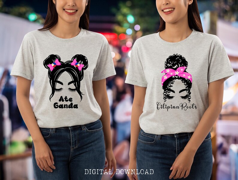 May include: Two gray t-shirts with a black and white illustration of a woman with a bun and a pink headband on one shirt and a woman with pigtails and pink bows on the other. The text "Ate Ganda" is on one shirt and "Filipina Roots" is on the other.