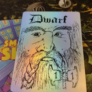 May include: A black and white illustration of a dwarf holding an axe. The card has a holographic background and the word "Dwarf" printed in black at the top.