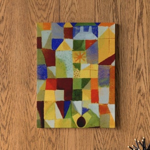 以下が含まれることがあります： 赤、黄、青、緑、白の色合いの幾何学的な形をしたカラフルな抽象画。絵は額装され、白い棚の上の壁にかけられている