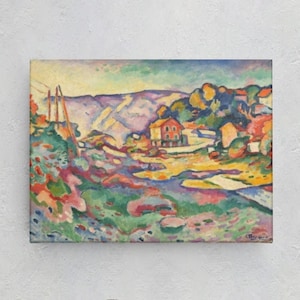May include: A colorful landscape painting with a village scene. The artwork features a vibrant palette of blues, greens, reds, and yellows, depicting houses, trees, and mountains. The painting is displayed on a white wall above a gray sofa and a small wooden table.