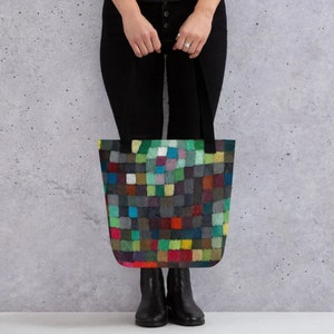 May include: A black tote bag with a colorful geometric pattern. The pattern is made up of squares of different colors, including red, green, blue, yellow, and purple.