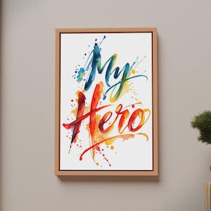 Könnte beinhalten: Ein rechteckiges gerahmtes Wandbild mit dem Text My Hero in einem lebendigen Aquarellstil. Das Wort My ist in Blau- und Grüntönen gehalten, während das Wort Hero in Rot, Orange und Gelb dargestellt ist, umgeben von farbenfrohen Farbspritzern.