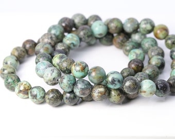 May include: A set of three turquoise gemstone bracelets with a mottled green and brown pattern. The bracelets are made of round beads.