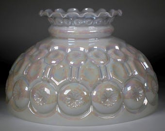 May include: A dome-shaped glass lamp shade featuring an iridescent finish and a repeating moon and star pattern. The shade has a ruffled, scalloped top edge and a wide, circular opening at the base, showcasing a translucent white glass.