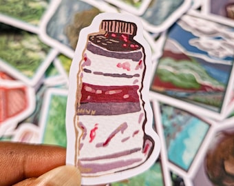 May include: A hand holding a sticker of a watercolor illustration of a crushed plastic bottle with a red and white label. The bottle is depicted as being crumpled and has a red lid.