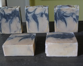 May include: Five bars of handmade soap with a marbled design in shades of beige and dark gray.
