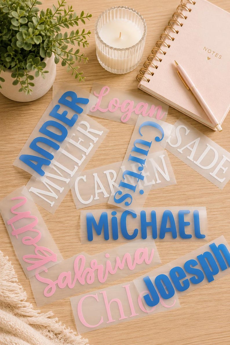 May include: A collection of rectangular clear adhesive labels featuring various names printed in different fonts and colors, including blue, pink, and white. The names visible are Ander, Miller, Logan, Curtis, Sade, Caren, Michael, Beth, Sabrina, Chloe, and Joesph.