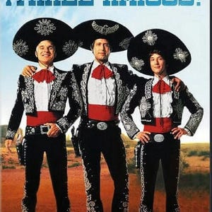 May include: DVD cover for the movie "Three Amigos!" featuring three men in traditional mariachi outfits. They wear black suits with silver embroidery, large sombreros, and red bow ties. The movie title is in large blue letters.