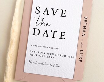 May include: A white save the date card with black text that reads "Save the Date", "We're getting married", "Saturday 28th March 2024", "Shustoke Barn", and "Formal invitation to follow". The card has a pink border with the names "Bethany" and "Luke" written vertically on the right side.