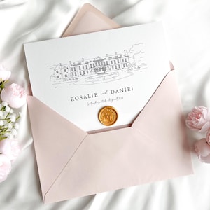 May include: A light pink envelope holds a white card with a black line drawing of a building and the names "Rosalie and Daniel" with a date. A gold wax seal is on the card. The envelope is on a white surface with pink flowers.