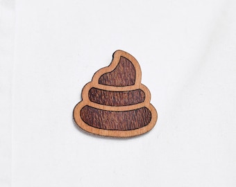 Piles of excrement as a pin, badge, brooch made of wood for a celebration or festival