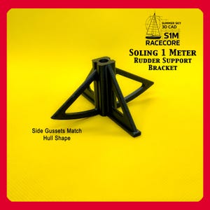 May include: Black Soling 1 Meter rudder support bracket. The bracket has a unique design with side gussets that match the hull shape. The text on the image reads "SOLING 1 METER RUDDER SUPPORT BRACKET".