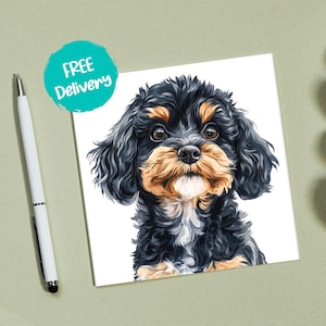 May include: A square print of a Cavalier King Charles Spaniel puppy with black, tan, and white fur. The puppy has large brown eyes and a fluffy coat. A teal circle with the words "FREE Delivery" is in the upper left corner.