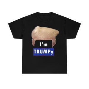 Könnte beinhalten: Schwarzes T-Shirt mit einem Aufdruck einer blonden Perücke und dem Text "I'm TRUMPY" in Blau und Weiß.
