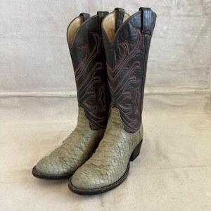 May include: A pair of tall cowboy boots featuring dark brown leather shafts with intricate red stitching patterns and light gray, textured snakeskin-patterned leather vamps and toe boxes, complete with pull straps at the top of each boot shaft.